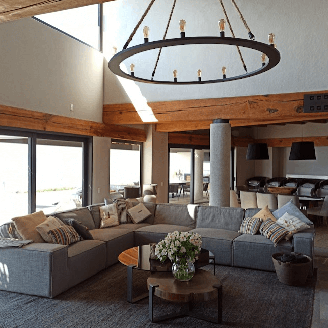 Sala con un candil circular, un sillón y unas mesas de centro