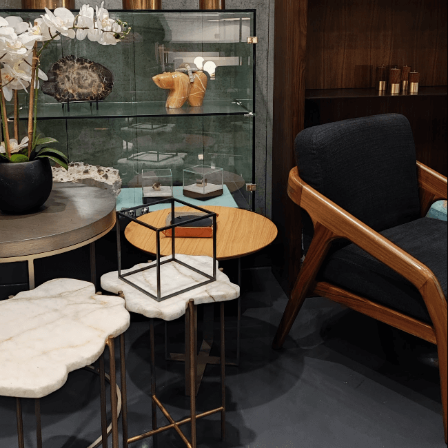 Poltrona de madera y mesas laterales de mármol