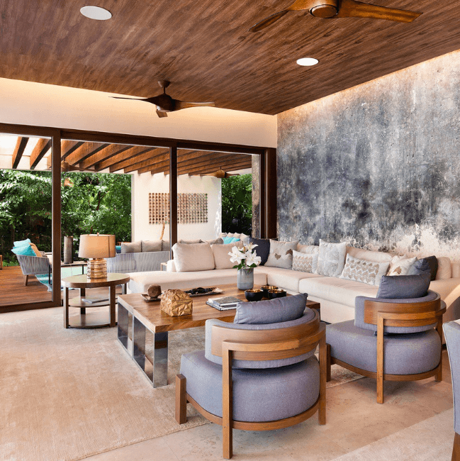 Sala que da al mar, con sillones tapizados y poltronas de madera